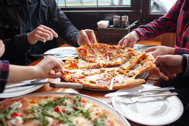 grupp studenter vänner äter italiensk pizza